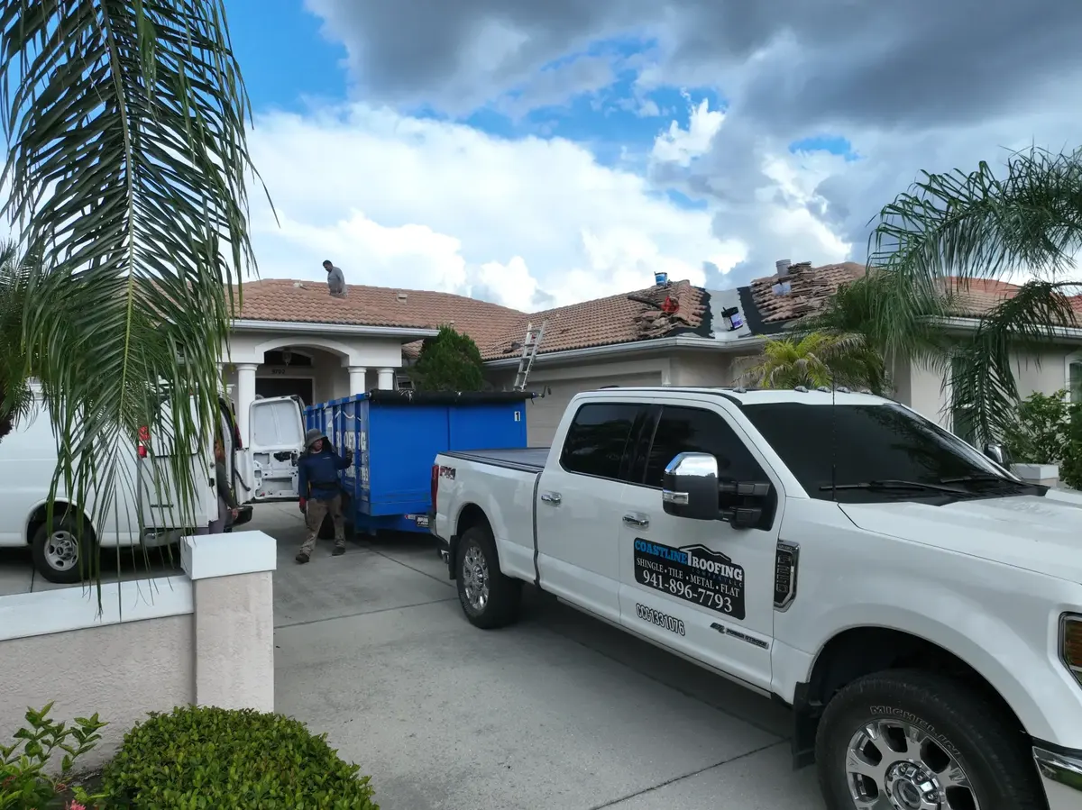 Coastline crew and branded truck during tile reroof, ground view, August 2024